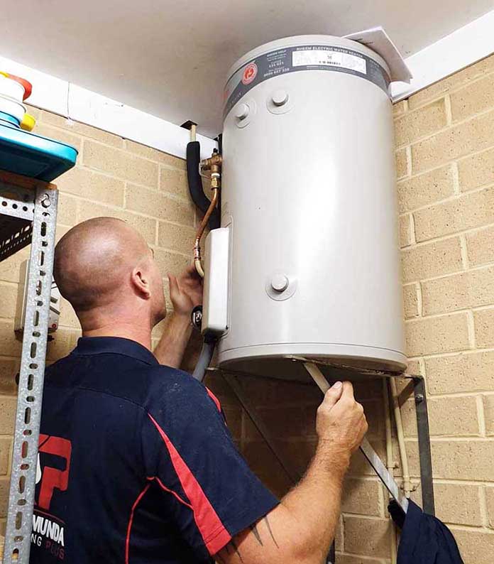 plumber installing an electric hot water heater