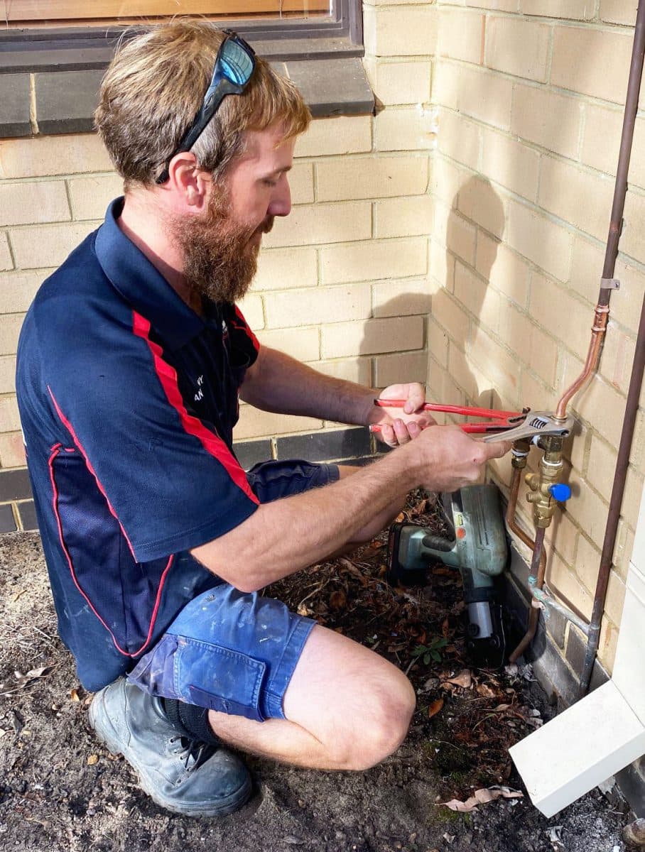 plumber installing hot water pipe